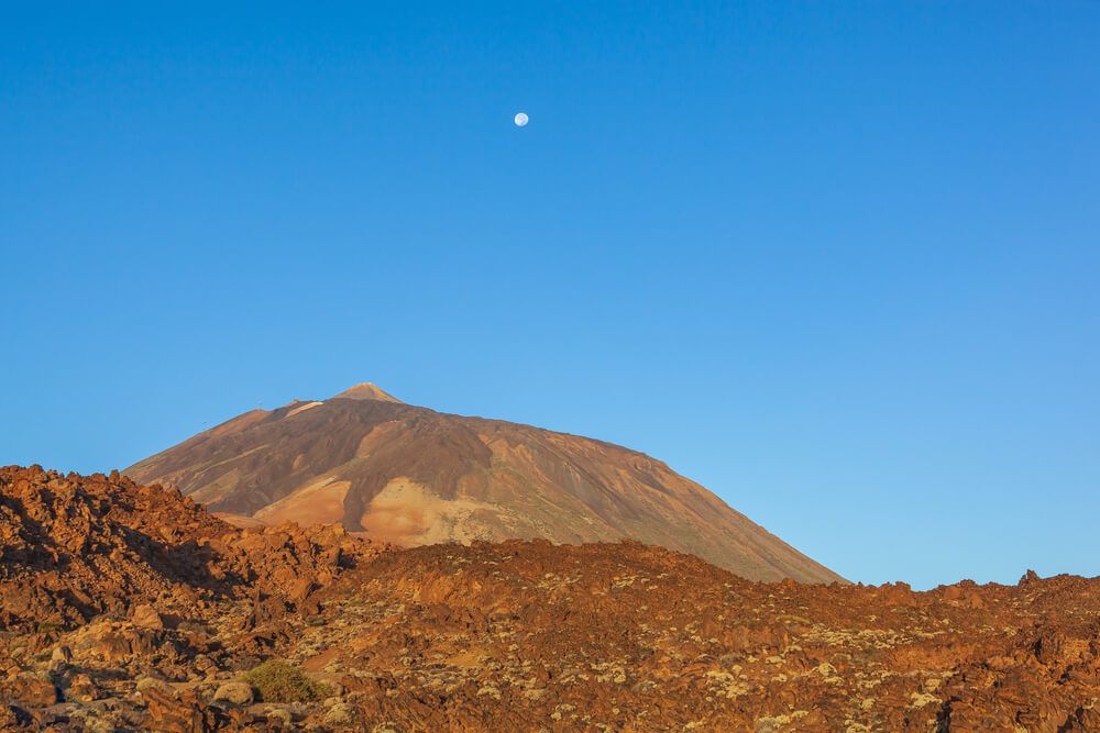 Majestic red volcanic terrain in the Teide national park with Mount Teide on the blue sky background in Tenerife.jpg